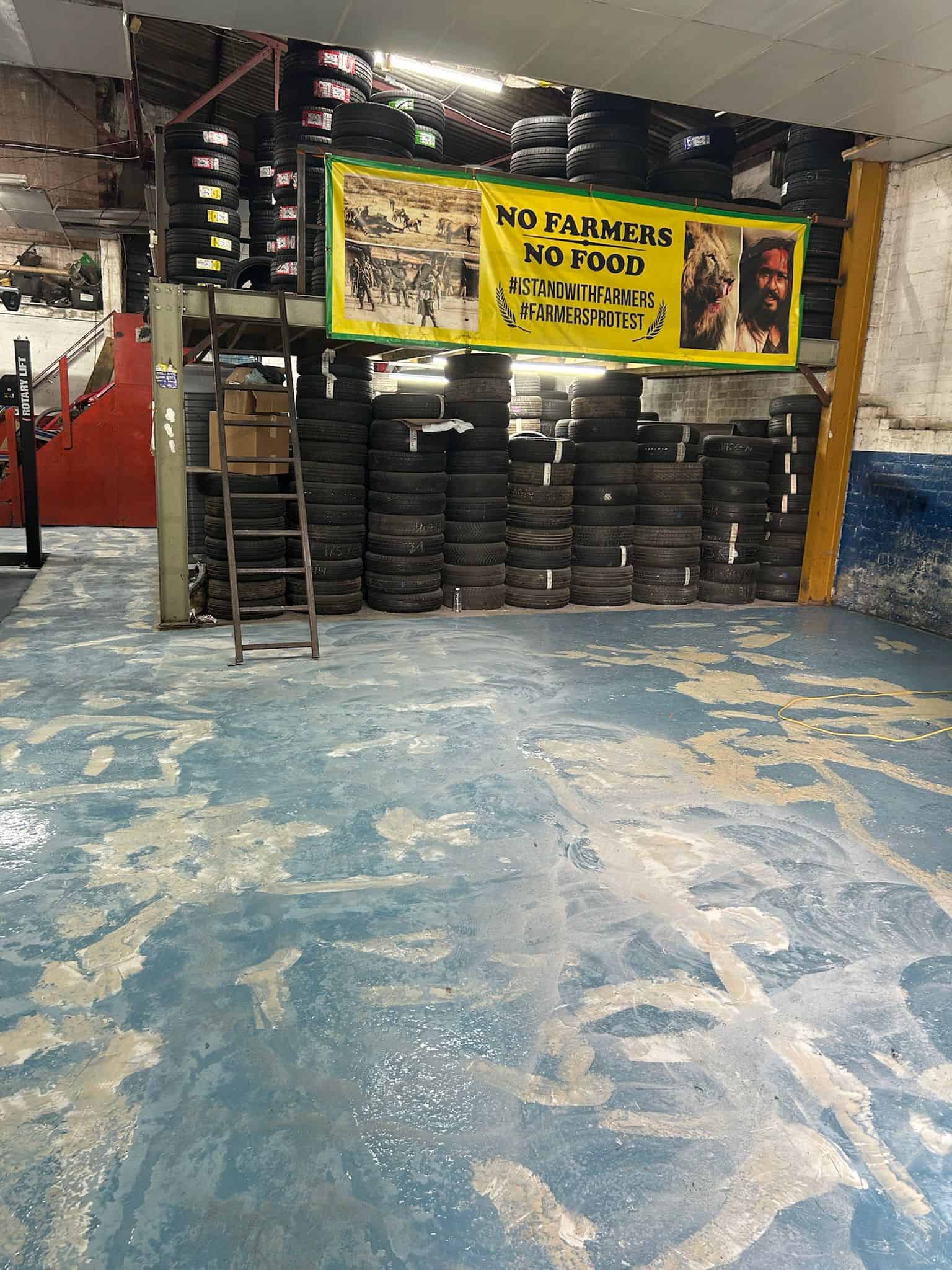 Commercial garage floor being prepared for epoxy resin coating, with surface cleaning, crack repair, and grinding to ensure a smooth and durable finish.